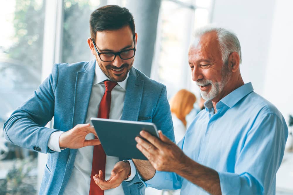 Two investors reviewing a tablet.